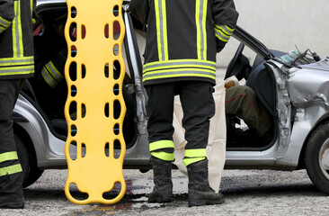 firefighters during rescue of the injured after the car accident with the stretcher to transport...
