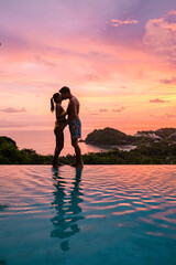 a young couple of men and women at a swimming pool during a vacation on a tropical island. man and...