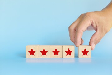 Five stars feedback, review and rating concept. Hand putting blocks with five stars shape.