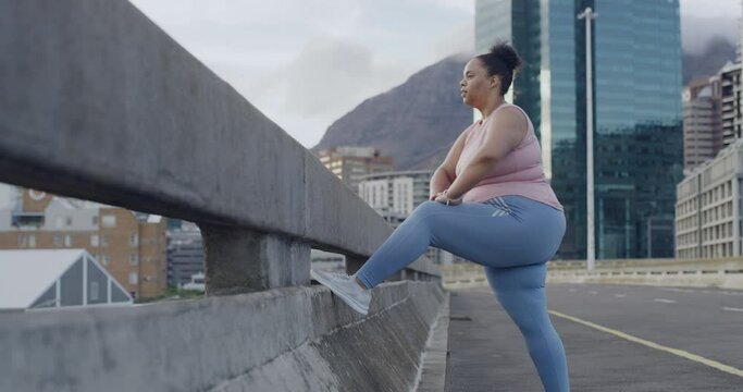 One plus size woman starting a weight loss journey and focusing on health, cardio, fitness and energy. Latin woman getting fit and stretching her legs before her workout in the city.