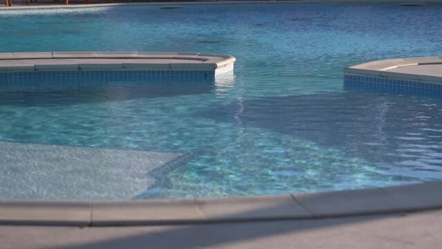 Details of a beautiful crystal clear blue water infinity pool. Summer holiday relaxation at the swimming pool.