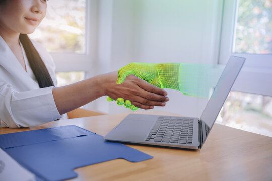 Smart Businesswoman shakehand with artificial intelligence hands visual effect from laptop computer. Human meet technology concept. Selected focus