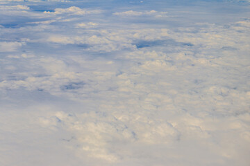 Beautiful white clouds in blue sky. View from airplane