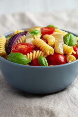 Homemade Fusilli Pasta Salad with Mozzarella and Vegetables, side view.