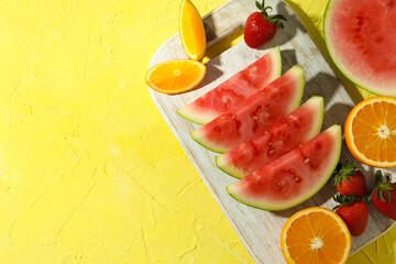 Fresh and juicy fruits on yellow textured background