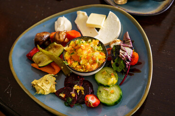 Plate with different food on a wooden table. Top view of the restaurant table with an assortment of meat side dishes, salads. Menu, business lunch, breakfast, plates of food in cafeteria