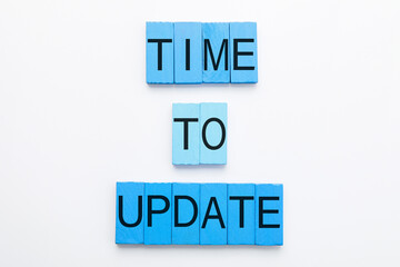 Text TIME TO UPDATE made of blue wooden blocks on white background