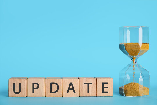 Hourglass and word UPDATE made of cubes on blue background