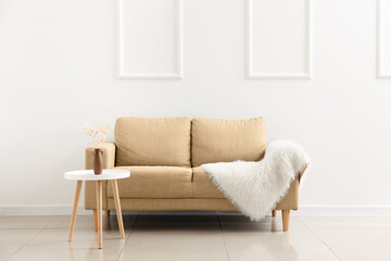 Beige couch and table near white wall
