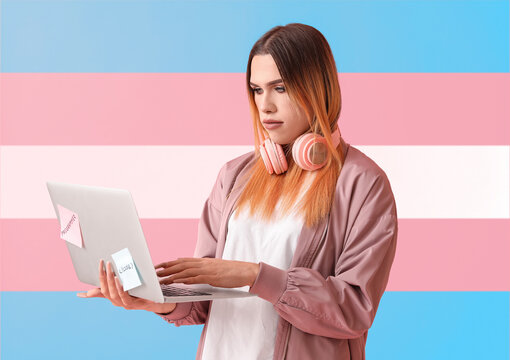 Transgender programmer with laptop on color background
