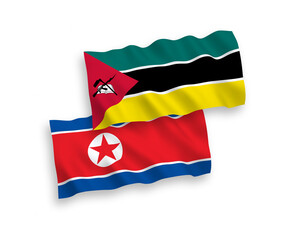 National vector fabric wave flags of North Korea and Republic of Mozambique isolated on white background. 1 to 2 proportion.