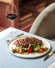 Schilderijen op glas Portion of gourmet roasted beef meat steak with glass of red wine © Hihitetlin