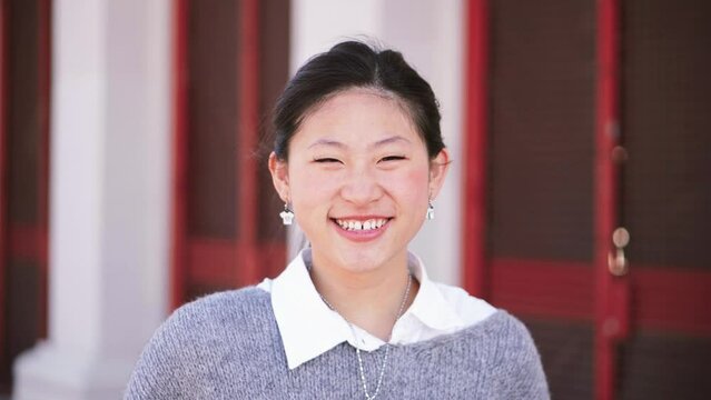  Close Up Portrait of happy Asian girl looking at camera. Chinese lady smiling and laughing outdoors