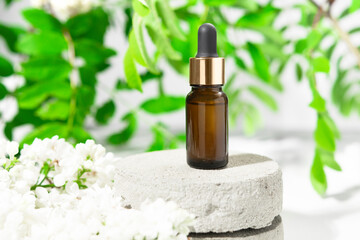 Glass brown bottle with facial serum, liquid collagen and peptide on a gray stone podium, skin treatment, body care.