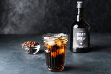 Glass with cold brew coffee on dark background