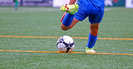 Junior soccer player kicking the ball	