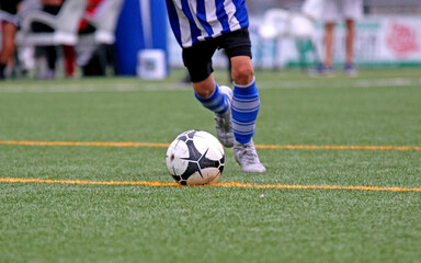 Junior soccer player kicking the ball	