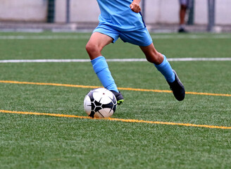Junior soccer player kicking the ball	