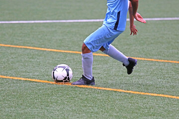 Junior soccer player kicking the ball	