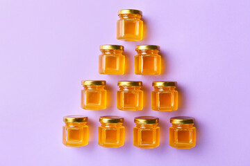 Jars with honey on purple background