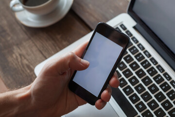 hand holding smartphone with empty blank screen, email, browsing mobile internet