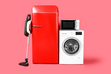 Modern household appliances on red background
