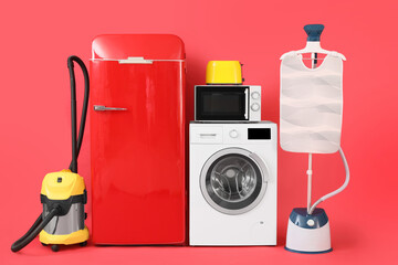 Modern household appliances on red background