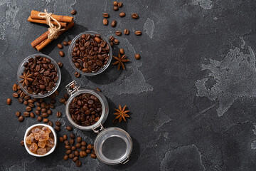 Coffee beans, cinnamon sticks and star anise on dark background top view