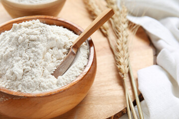 Bowl with wheat scoop on wooden board, closeup