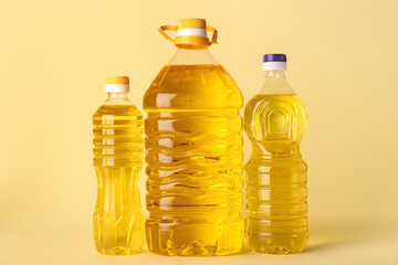 Different bottles of sunflower oil on color background