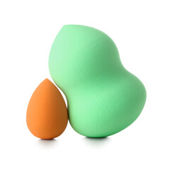 Different make up sponges on white background