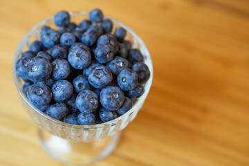 blueberries in a vase on a wooden table. Sweet dessert.