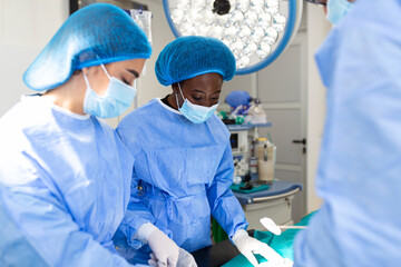 Surgeon team in uniform performs an operation on a patient at a cardiac surgery clinic. Modern...
