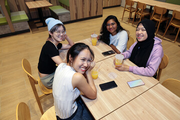 young attractive Asian group woman friends colleagues students indoor dining café restaurant area...