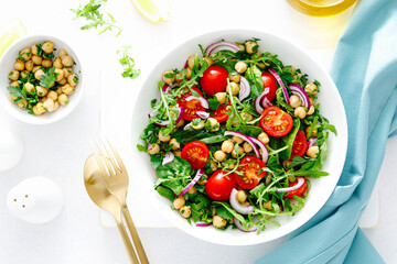 Vegetarian chickpea salad with tomatoes, arugula, parsley, spinach and red onion. Healthy food, diet. Top view