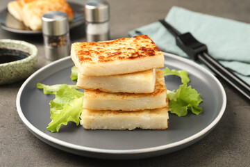 Delicious turnip cake with lettuce salad served on grey table