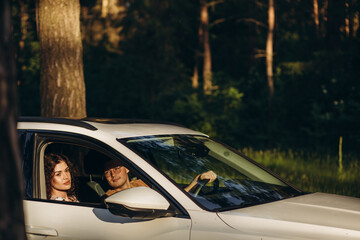 road trip, travel, dating, couple and people concept - happy man and woman driving in cabriolet car outdoors
