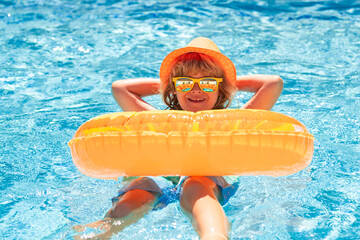 Kid boy relaxing in pool. Child swimming in water pool. Summer kids activity, watersports. Summer...