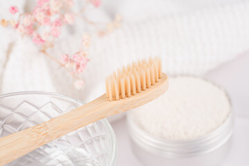 Closeup view of bamboo toothbrush with mineral toothpowder kaolin in alu container over white table...