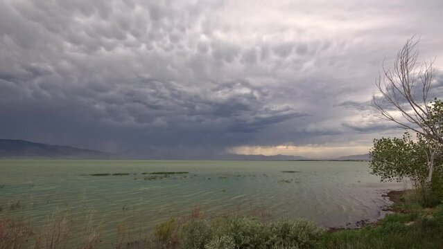 Panning Utah Lake as storm moves over the landscape as wind blows dirt and dust in the sky.