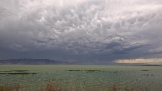 Panning storm structure over Utah Lake with mammatus clouds as the wind blows.