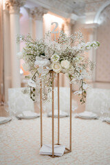Wedding centerpieces, with metal vase and white fresh flowers arrangements.
