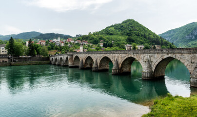The Ottoman Mehmed Pasa Sokolovic Bridge in Visegrad, Bosnian mountains, reflected in the river Drina, Bosnia and Herzegovina.
