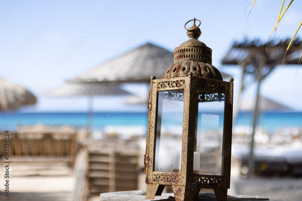 Wall mural Vintage lantern on a tropical beach club background.