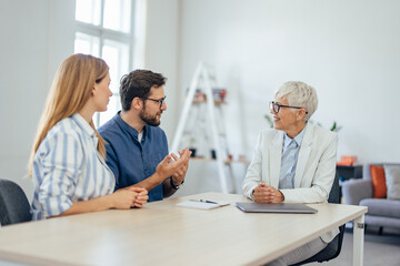 Couple explaining something to the insurance agent, at the office.