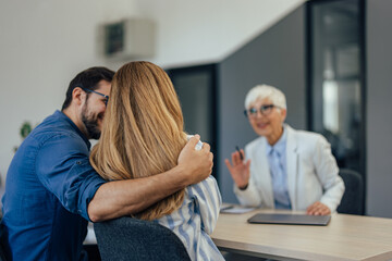 Focus on the young couple at the insurance agent's office.