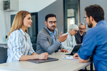 Business people having a meeting in the meeting room, sitting around the table.