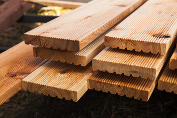 Stacked larch deck boards, close up outdoor photo - obrazy, fototapety, plakaty