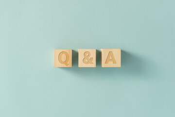 QA sign on wooden cubes on the blue background