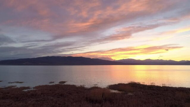 Panning view of colorful sunset over Utah Lake from Vineyard where soon homes will block this view of the lake.
